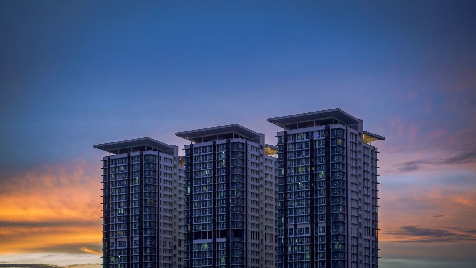 Three towers against a dusk sky