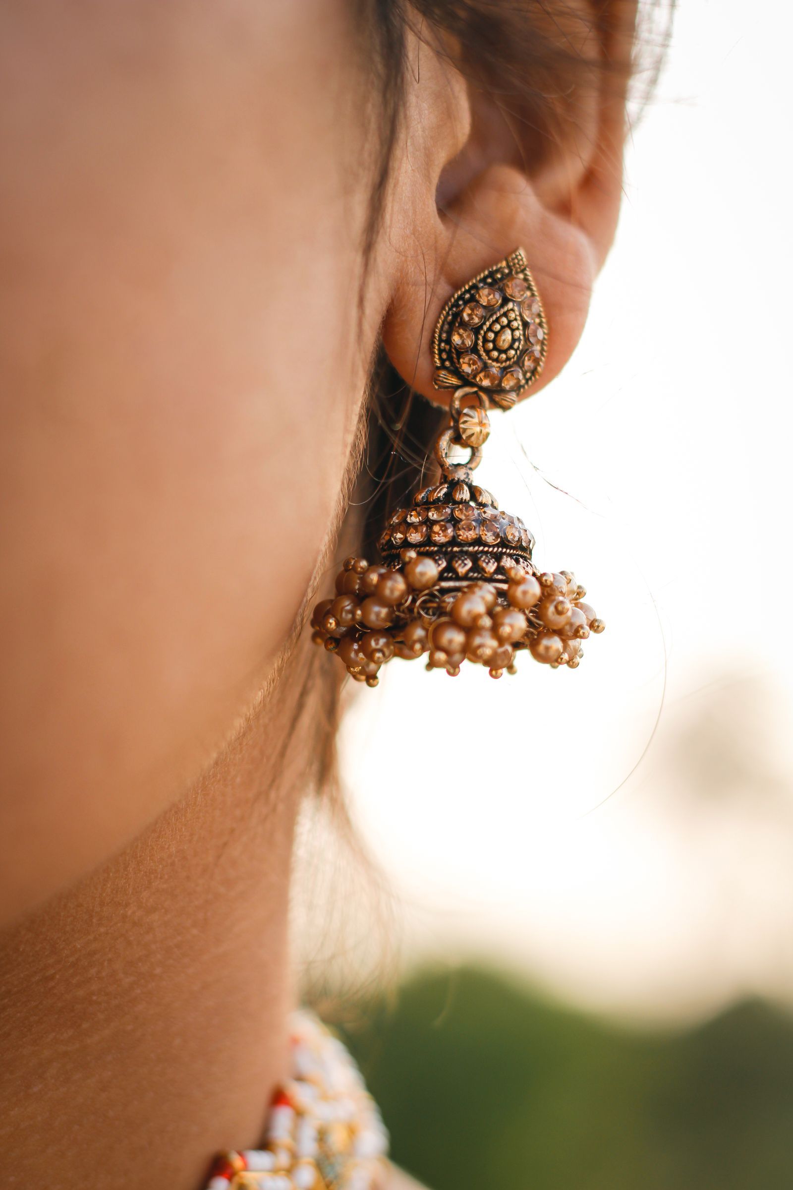 A gold jhumka earring, close up