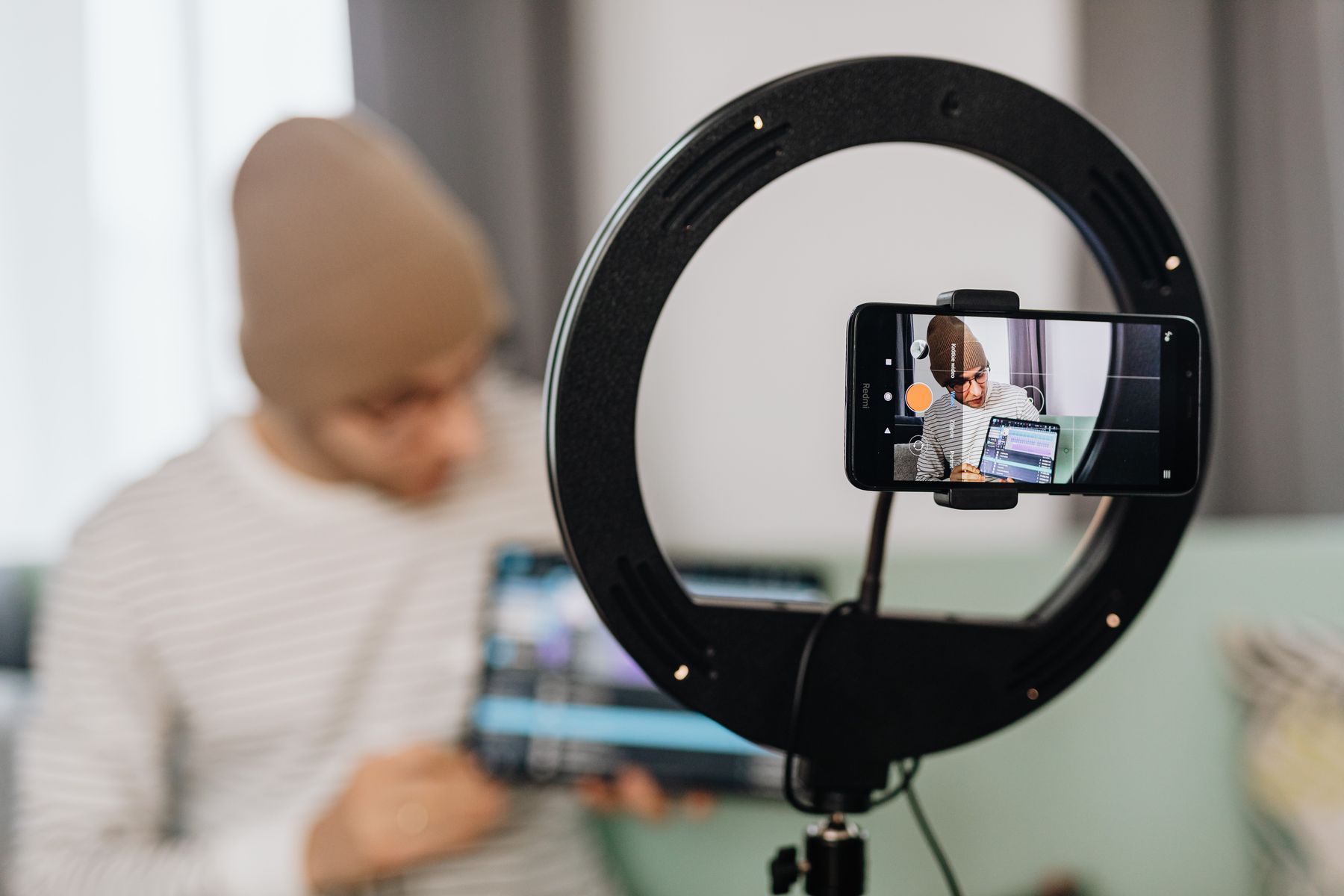 A creator filming a reel with a phone and a ring light