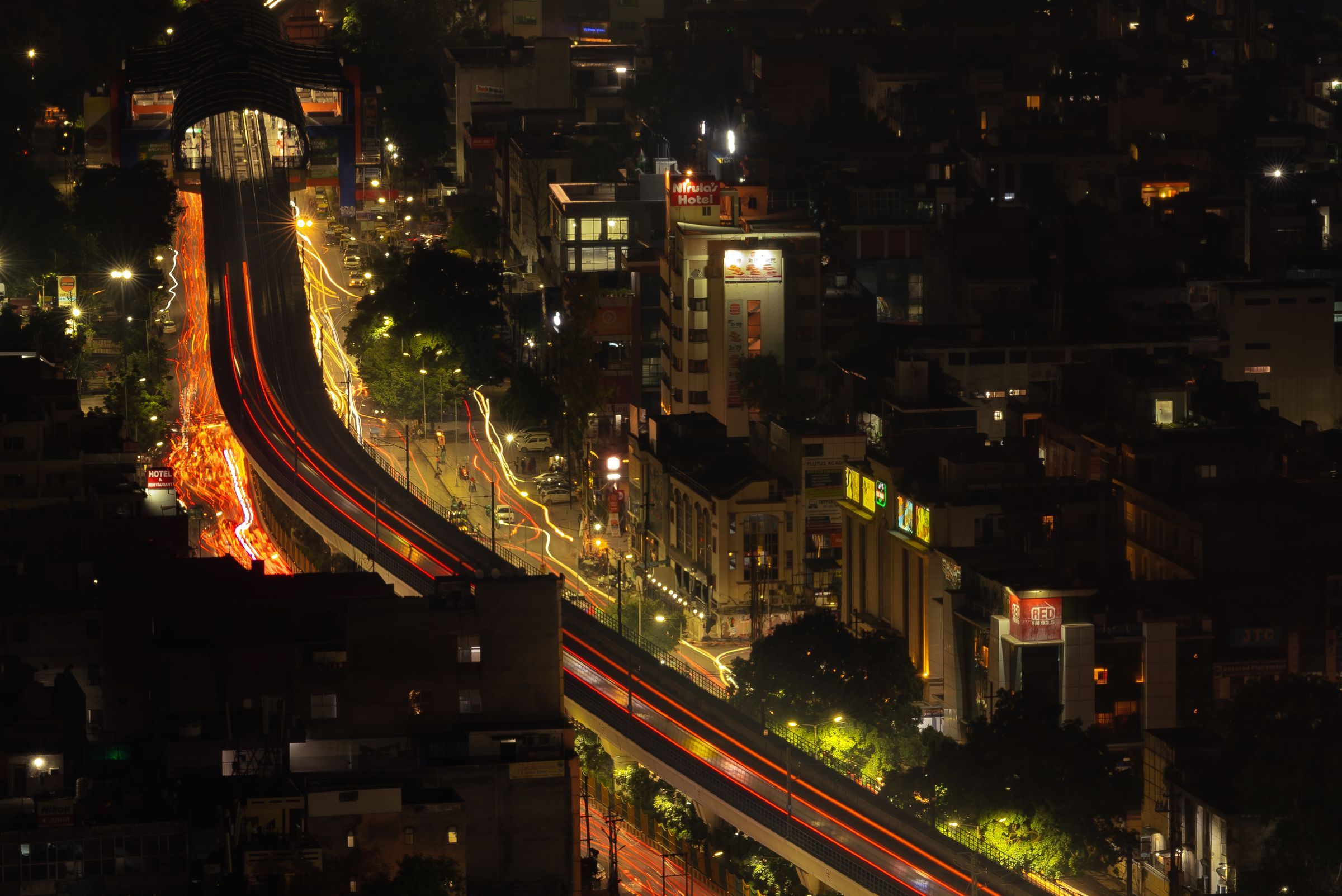 An Indian city at night from above, its roads drawn in orange light