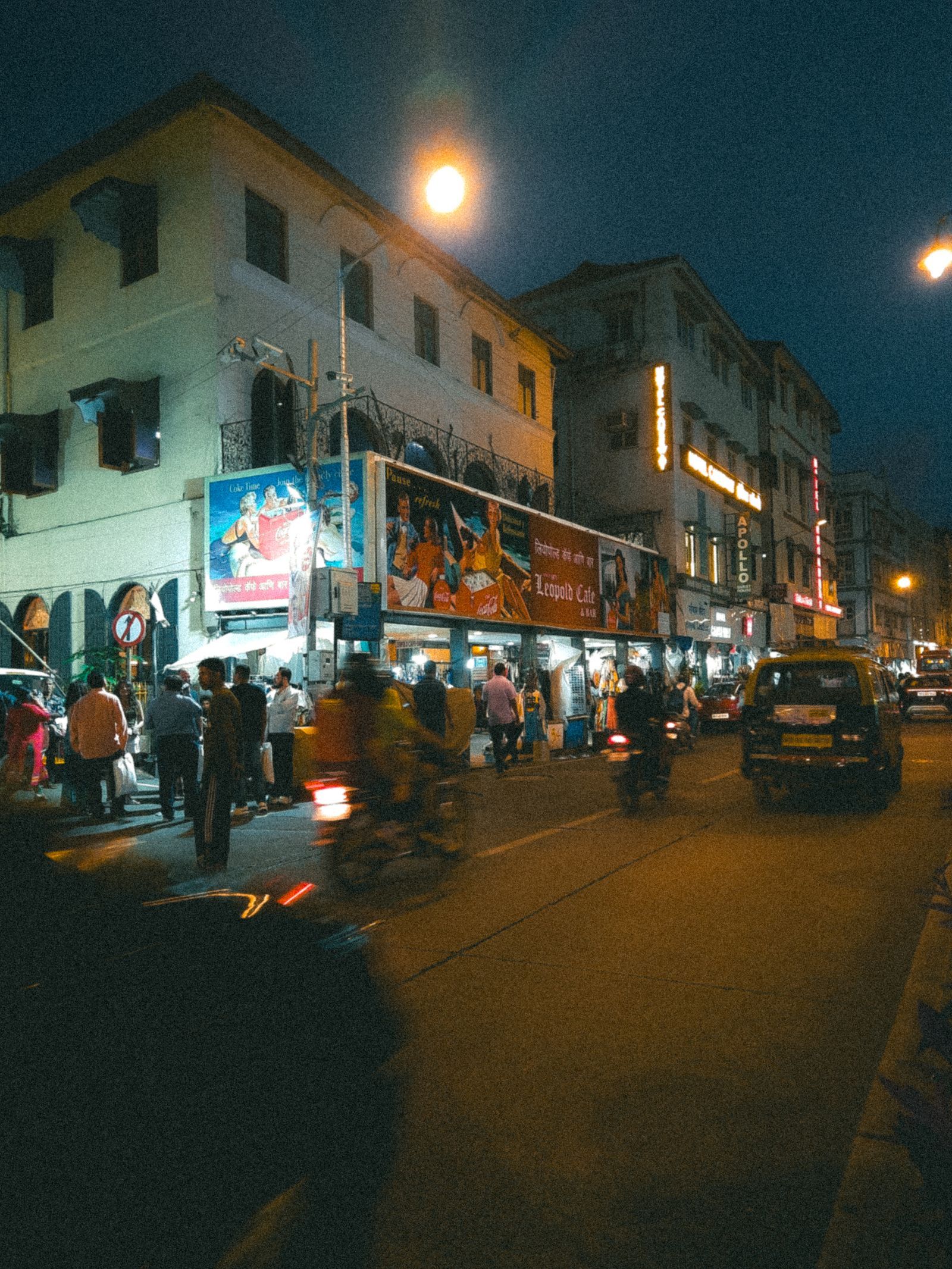 A large hoarding above a busy Indian street at night